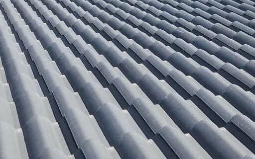 Detalle de un tejado gris con filas de tejas alineadas, sin edificios de fondo